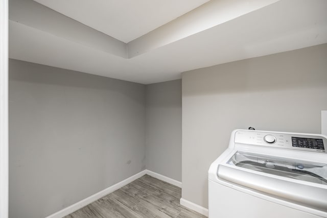 laundry room with washer / clothes dryer and light hardwood / wood-style flooring