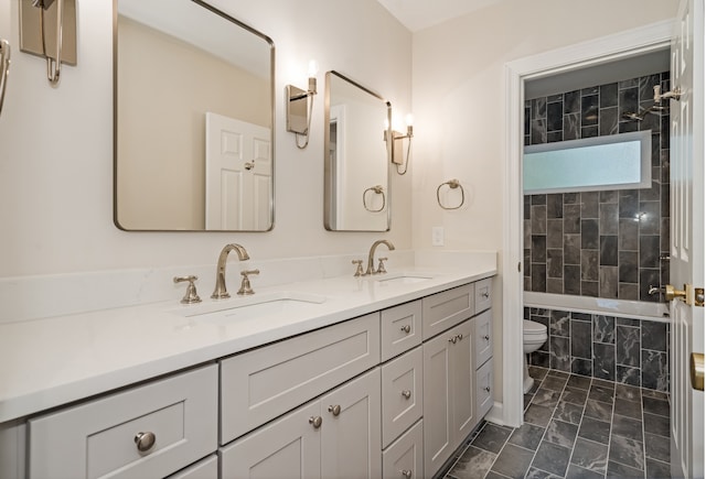 full bathroom with tiled shower / bath combo, toilet, and vanity