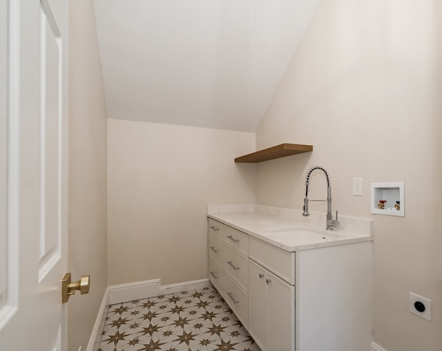 clothes washing area featuring hookup for an electric dryer, cabinets, sink, and washer hookup