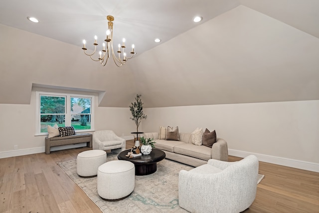 living room with light hardwood / wood-style floors, lofted ceiling, and a chandelier