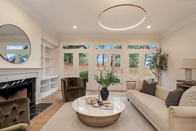 living room featuring light hardwood / wood-style floors, a wealth of natural light, and ornamental molding