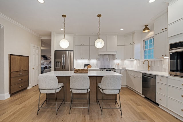 kitchen featuring appliances with stainless steel finishes, a center island, light hardwood / wood-style flooring, and white cabinetry