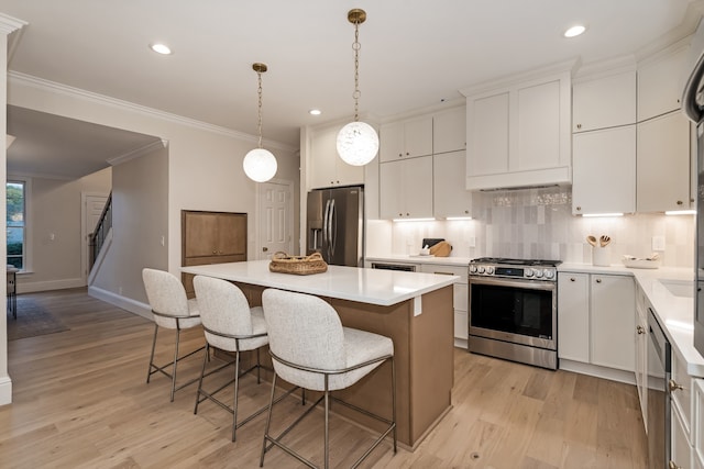 kitchen with white cabinetry, a center island, stainless steel appliances, and light hardwood / wood-style floors