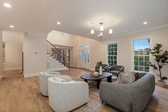 living room with crown molding, light hardwood / wood-style floors, and a notable chandelier