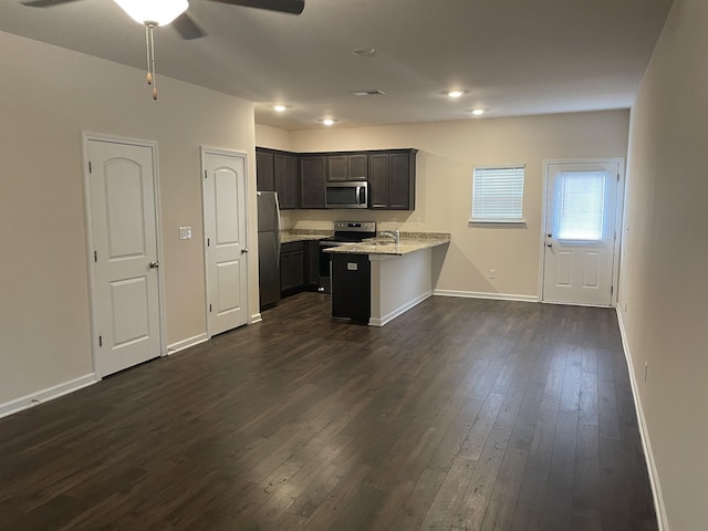 kitchen featuring kitchen peninsula, dark hardwood / wood-style flooring, stainless steel appliances, and light stone countertops