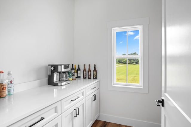 bar with white cabinetry and dark hardwood / wood-style floors