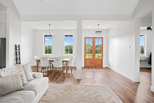 living room with lofted ceiling, light hardwood / wood-style flooring, and ceiling fan with notable chandelier