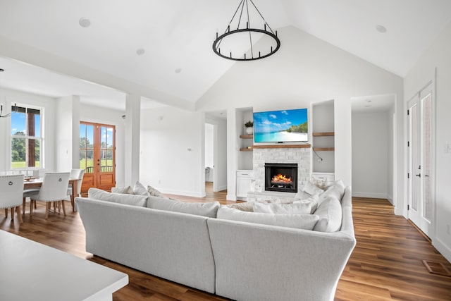 living room with a stone fireplace, hardwood / wood-style flooring, and high vaulted ceiling