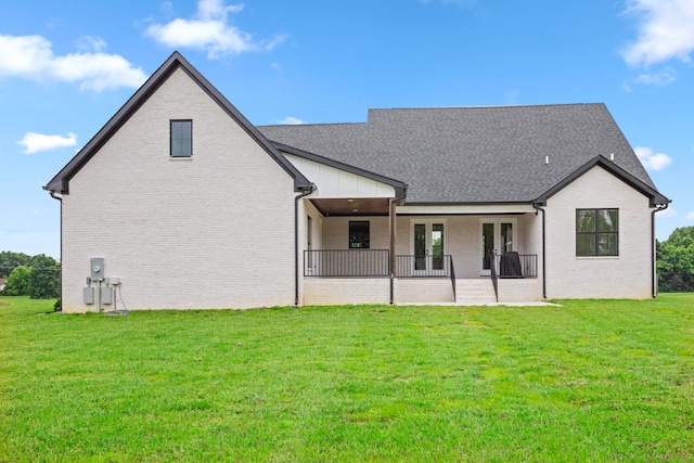 rear view of property featuring a lawn