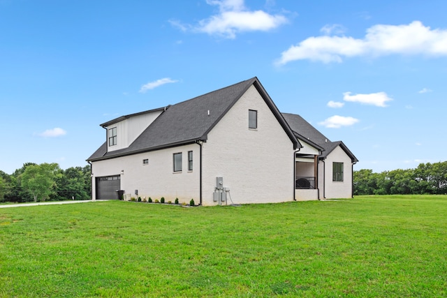 view of side of home featuring a lawn and a garage