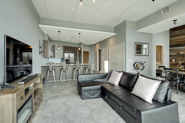 living room with a high ceiling and light wood-type flooring