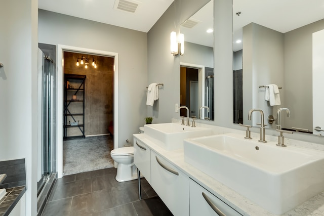 bathroom featuring vanity, toilet, tile patterned flooring, and an enclosed shower