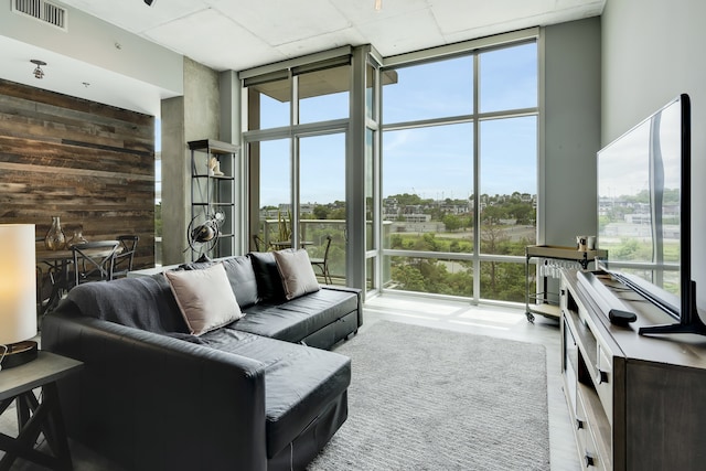 living room with a wealth of natural light, expansive windows, and a towering ceiling