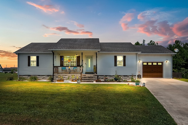 single story home featuring a garage, a lawn, and a porch