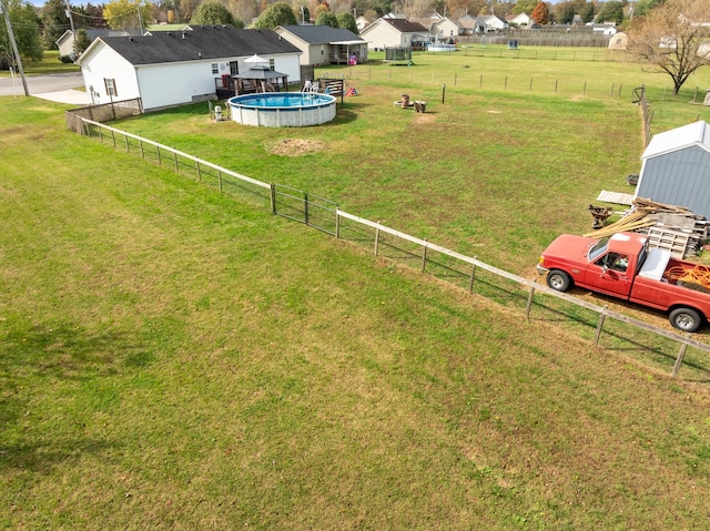 view of yard with a shed, a fenced in pool, and a rural view