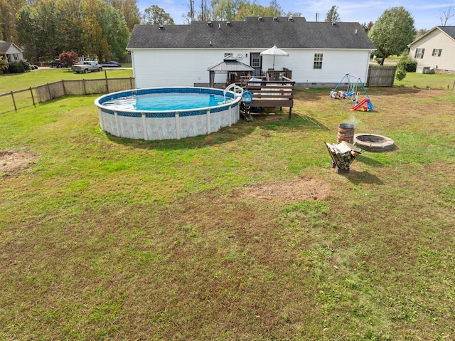 view of yard featuring an outdoor fire pit, a gazebo, and a pool side deck