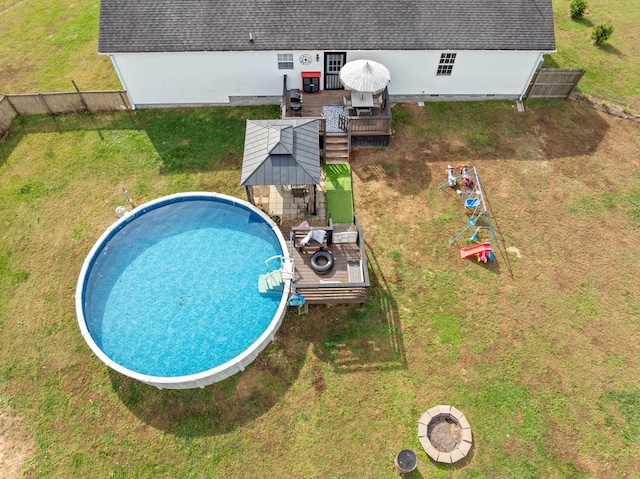 view of swimming pool with a deck and a lawn