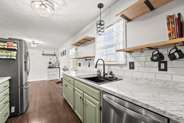 kitchen featuring stainless steel appliances, green cabinets, sink, dark hardwood / wood-style floors, and backsplash