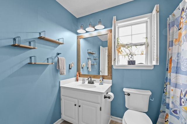 bathroom featuring toilet, vanity, and a textured ceiling