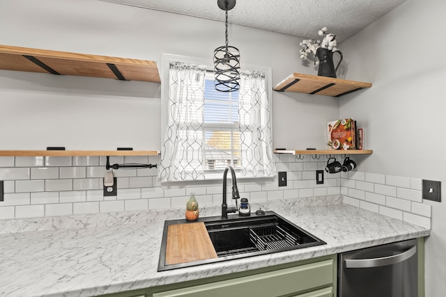 kitchen with backsplash, green cabinets, hanging light fixtures, sink, and dishwasher