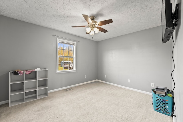 spare room with carpet, a textured ceiling, and ceiling fan