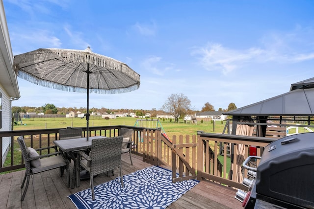 deck featuring a gazebo, a playground, a lawn, and a grill