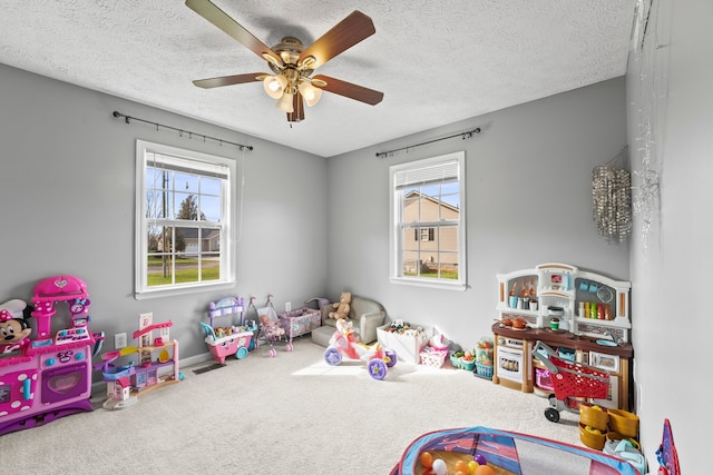 playroom with a textured ceiling, ceiling fan, and carpet floors