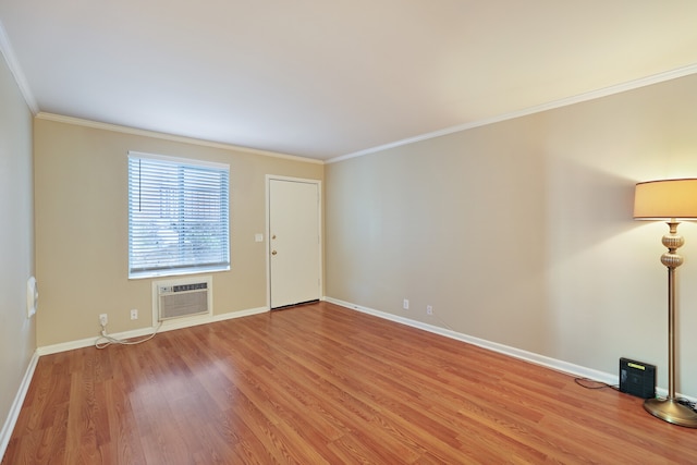 unfurnished room featuring a wall mounted AC, ornamental molding, and light hardwood / wood-style flooring