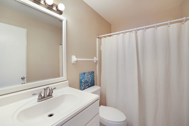 bathroom featuring vanity, curtained shower, and toilet