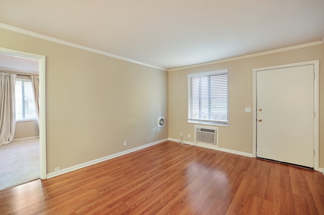 interior space with ornamental molding, a wall unit AC, and light hardwood / wood-style floors