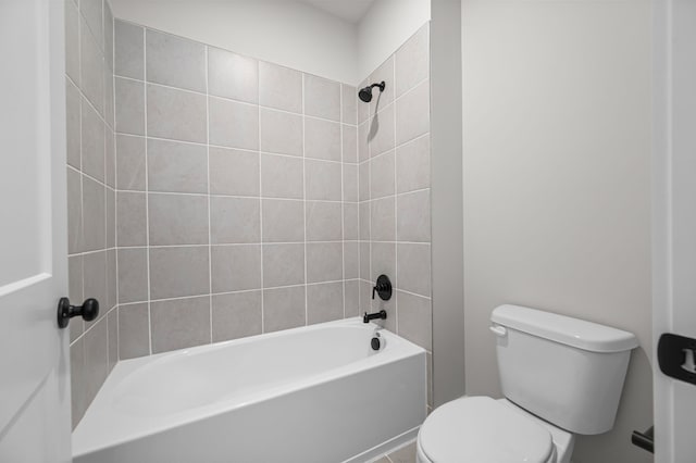 bathroom featuring tiled shower / bath combo and toilet