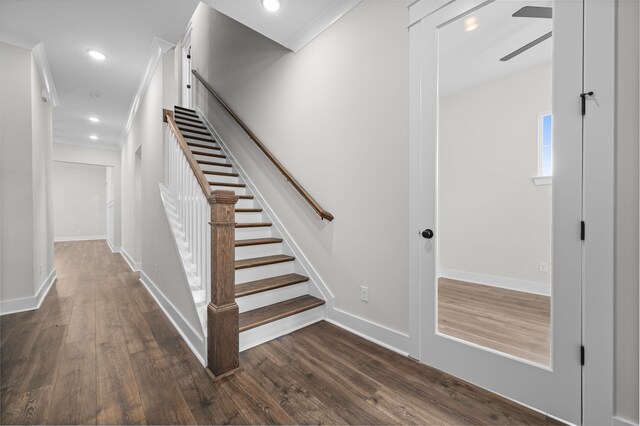 stairway featuring ceiling fan, wood-type flooring, and ornamental molding