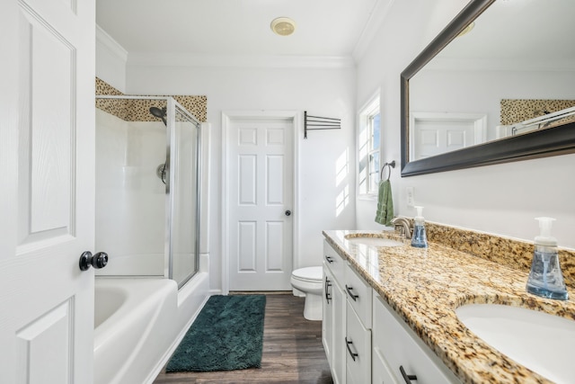 bathroom with double vanity, toilet, ornamental molding, wood finished floors, and a sink