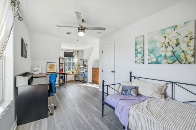 bedroom with a ceiling fan, visible vents, and wood finished floors