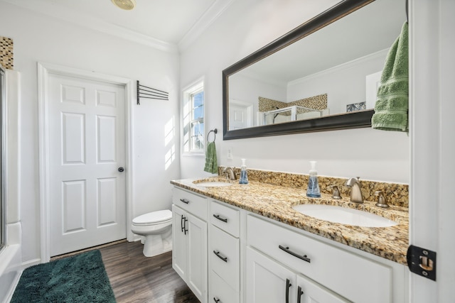 full bathroom with hardwood / wood-style flooring, ornamental molding, enclosed tub / shower combo, vanity, and toilet