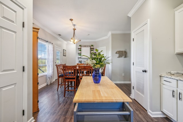 dining area with an inviting chandelier, baseboards, dark wood finished floors, and crown molding