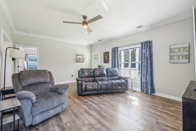 living room featuring wood-type flooring, ceiling fan, and crown molding