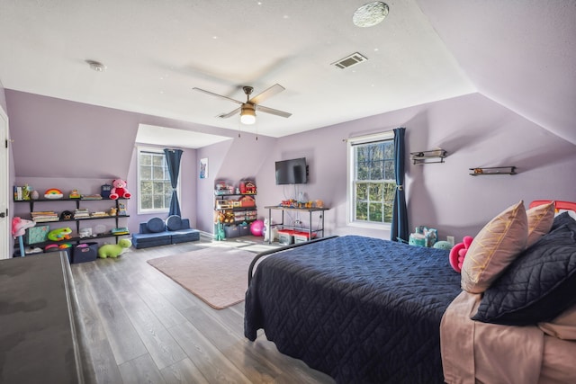 bedroom with lofted ceiling, ceiling fan, visible vents, baseboards, and light wood-type flooring