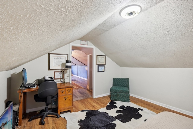 office featuring light hardwood / wood-style floors, lofted ceiling, and a textured ceiling