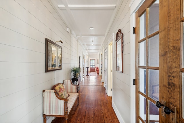 corridor featuring dark hardwood / wood-style floors, beamed ceiling, and wooden walls