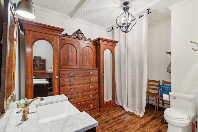 bathroom with beam ceiling, ornamental molding, wood-type flooring, and toilet