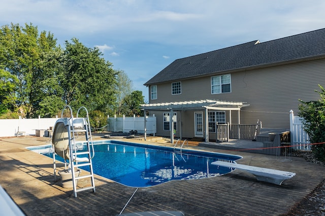 view of pool with a pergola, a water slide, a diving board, and a patio area