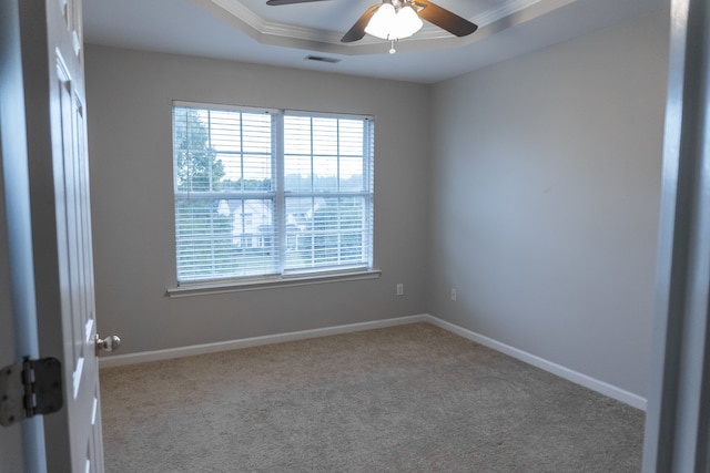 unfurnished room with light carpet, crown molding, a tray ceiling, and ceiling fan