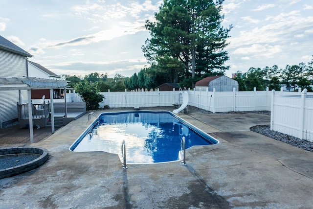 view of pool featuring a water slide, a patio, and a pergola