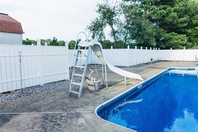 view of pool with a patio and a water slide