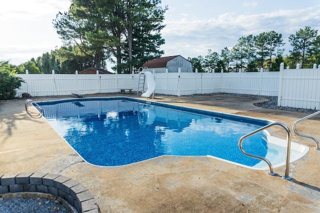 view of swimming pool with a patio and a water slide