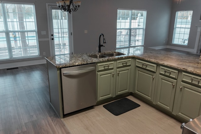 kitchen with light hardwood / wood-style flooring, kitchen peninsula, sink, an inviting chandelier, and stainless steel dishwasher