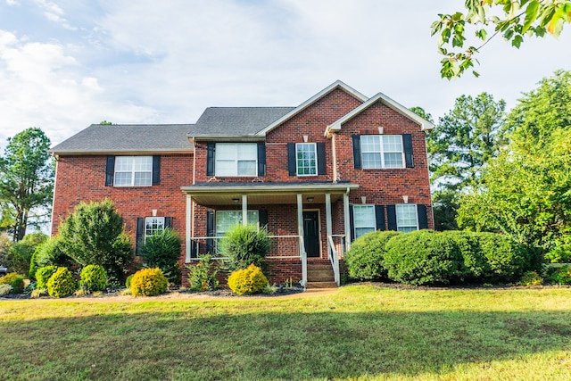 view of front of home with a porch and a front lawn