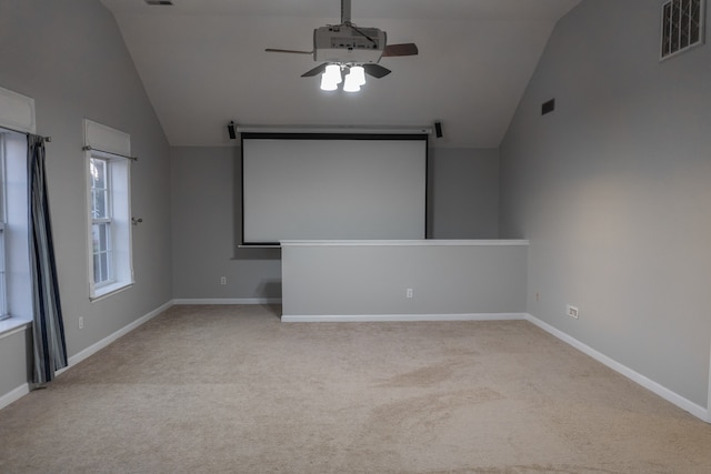 cinema with light carpet, lofted ceiling, and ceiling fan