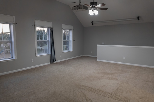 empty room with lofted ceiling, light colored carpet, and ceiling fan